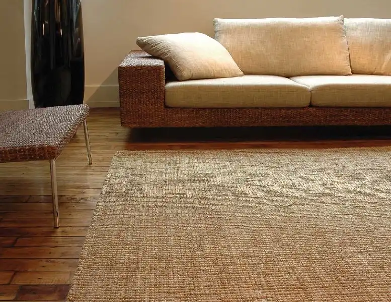 Large rectangular jute rug in a sunlit room with wooden furniture.